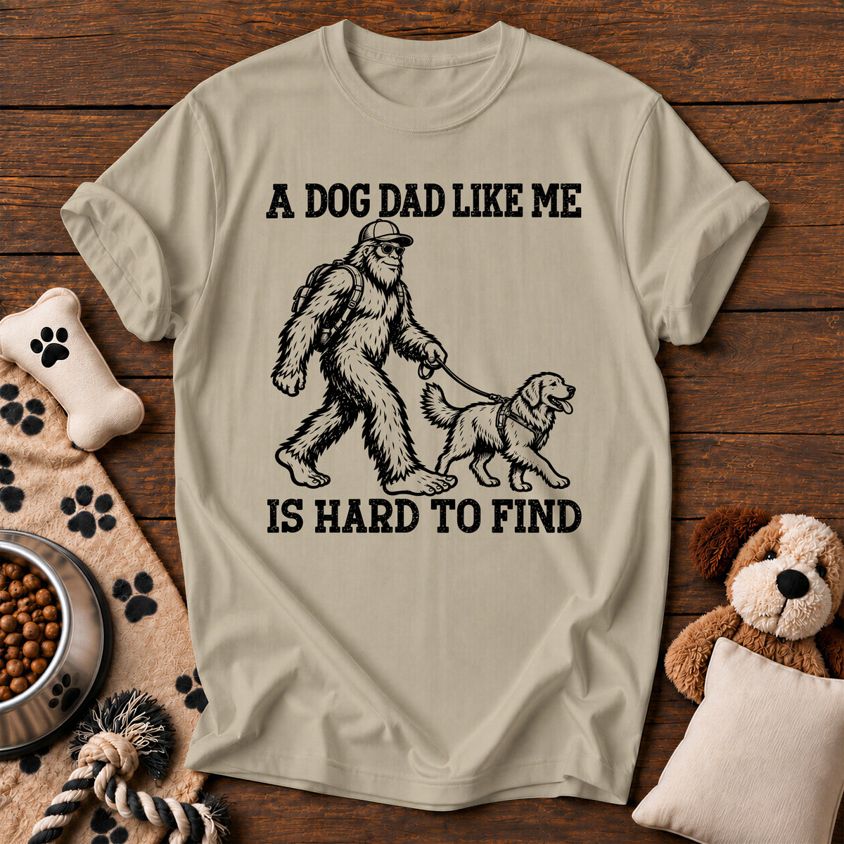 Bigfoot Dog Dad Tee — funny dog t-shirt in Sandstone, Comfort Colors 1717 flat lay