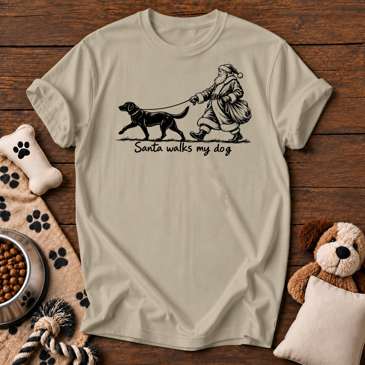 Santa Walks My Dog Christmas Tee — funny dog t-shirt in Sandstone, Comfort Colors 1717 flat lay